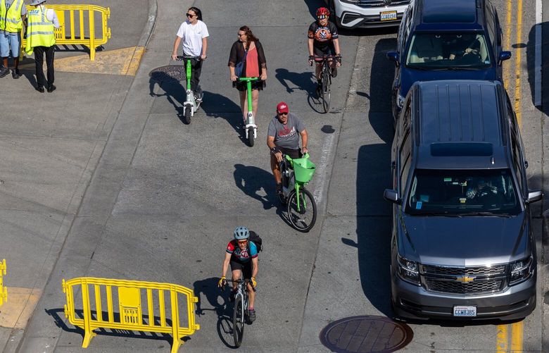 Bicyclists weave their way through the cruise line traffic Saturday morning at on Alaskan Way in Seattle, Washington on May 20, 2023.