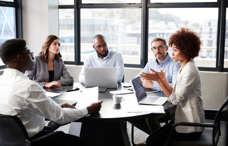 Millennial black businesswoman addressing colleagues at a corporate business meeting, close up