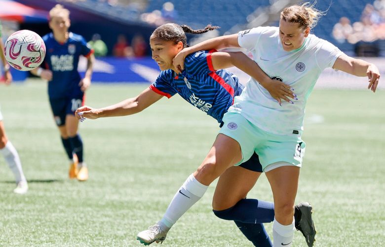 Racing Louisville FC defender Elli Pikkujamsa tries to hold back OL Reign forward Elyse Bennett during the first half. 224323