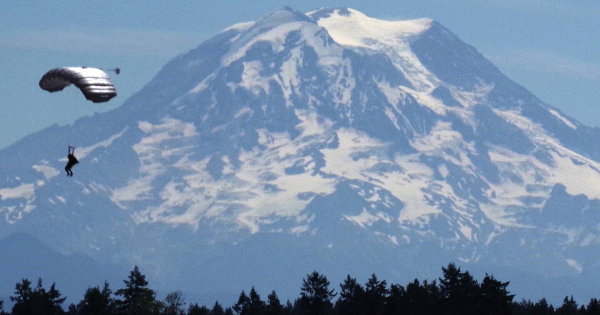 Mount Rainier makes a beautiful backdrop for four sky divers at JBLM