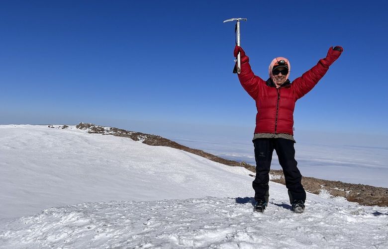 Rose Vanderhoof stands at the summit of Mt. Rainier.