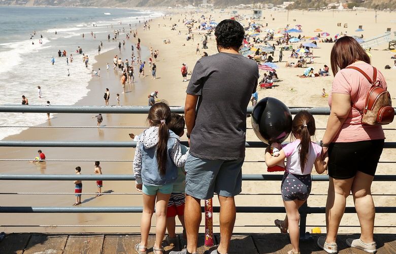 At the Santa Monica pier, a family watches beachgoers in 2021. (Al Seib/Los Angeles Times/TNS)