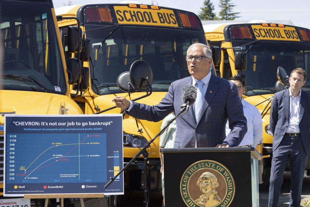 Gov. Jay Inslee and state legislators held a news conference Thursday at Highline Public Schools’ maintenance facility in Burien to talk about gasoline prices and oil company profits. They are standing in front of some of the school district’s four electric buses. At far right is state Rep. Joe Fitzgibbon.