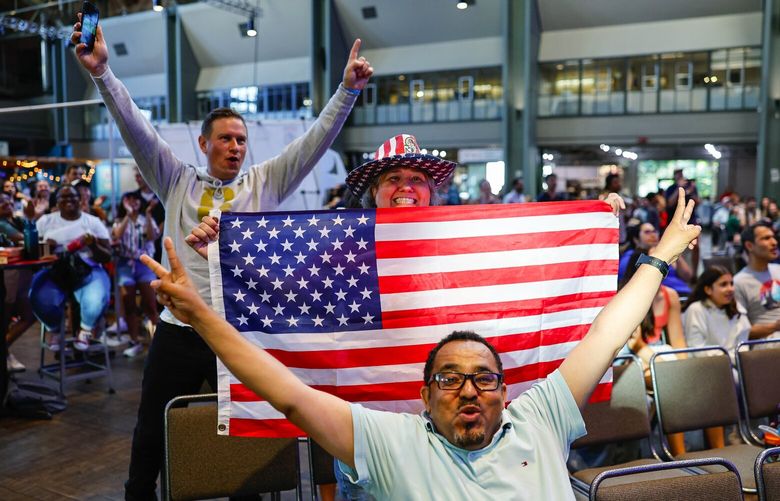 Mohammed Abdul-Kadir, foreground, and Kathleen Carosi celebrate the USA’s second goal scored against Vietnam in Friday’s Women’s World Cup game at a watch party Friday evening at the Seattle Center Armory. 224488