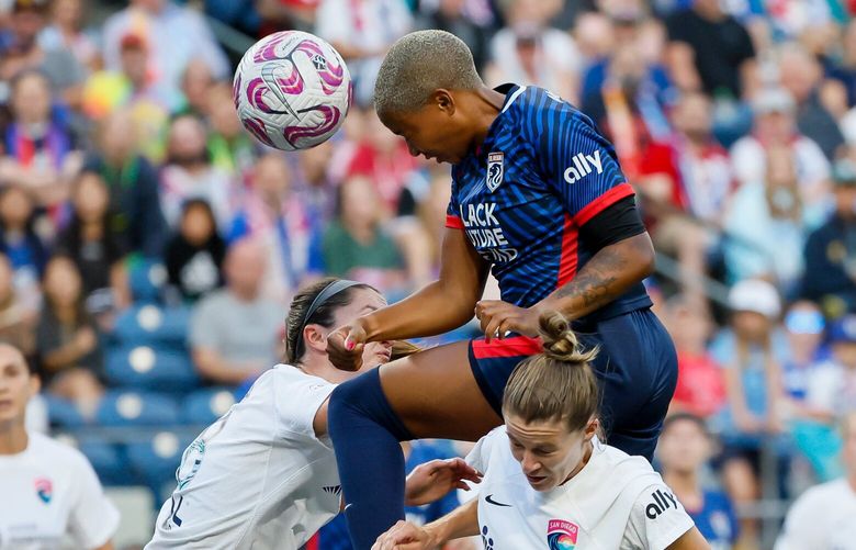 OL Reign forward Tziarra King just misses get on the end of a cross as she jumps over San Diego Wave FC defenders Kaleigh Riehl, left, and Christen Westphal during the first half. 224563