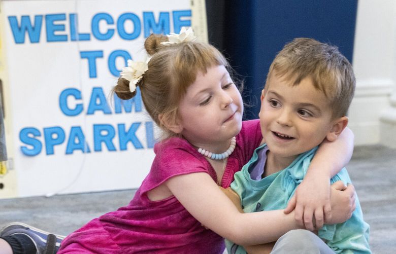 New friends Moxie Muir (5 3/4 years old) and Leo Whiteside, 5, who met just a few days before at Camp Sparkle, hang out together during “Welcome Circle” at the  camp Tuesday, July 25, 2023.  Moxie’s mother’s is a cancer survivor, Leo’s dad has cancer.  
A huge group of children and counselors attend a week-long camp for cancer patients and their families as part of Camp Sparkle held at what was once known as Gilda’s Club located at 1400 Broadway on Seattle’s Capitol Hill Wednesday, July 26, 2023.  The camp offers  supportive experience for any child navigating their own cancer diagnosis or a loved one’s. Campers spend a week learning about cancer, participating in therapeutic activities, and making friends with campers and counselors who are just like them.

 224540