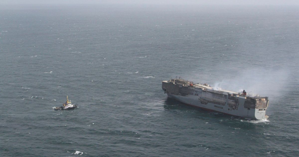 Salvage crews begin towing a burning cargo ship to a new location off ...
