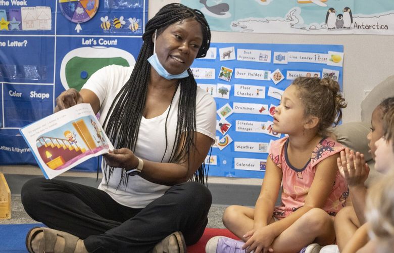 Dorothy Phillips, a teacher at Madrona Elementary School in Seattle, reads a book to students in her class Thursday, July 27, 2023.  The school is for students from preschool through middle school.  Child care availability in the Seattle area has been hit by inflation and there is a shortage.  224558
