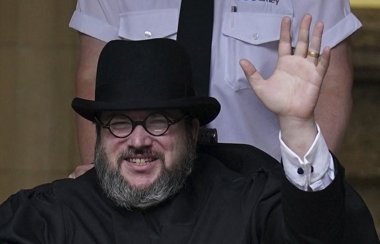 Nicholas Rossi from he U.S. waves as he leaves the Edinburgh Sheriff and Justice of the Peace Court in Edinburgh, Scotland, Wednesday, July 12, 2023. An American fugitive accused of faking his own death to avoid a rape charge has been ordered by a judge in Scotland to be returned to the U.S. The man known as Nicholas Rossi was ordered extradited Wednesday after fighting the case for nearly two years. (Andrew Milligan/PA via AP) DSOB105 DSOB105