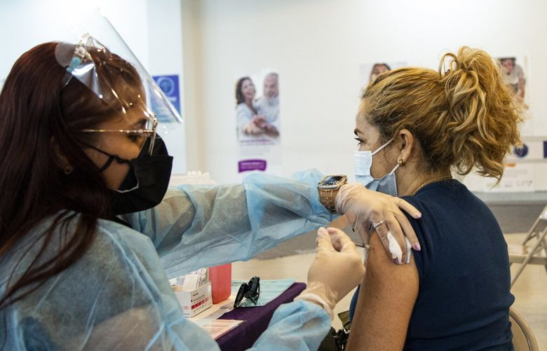 FILE – A woman receives a COVID-19 vaccine booster shot in San Juan, P.R., on May 20, 2022. Infections remain very low, despite signs of a slight increase and now, experts are looking for clues to what living with the coronavirus will be like this winter and beyond. (Erika P. Rodriguez/The New York Times)