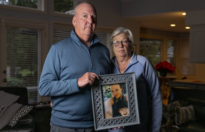 Parents Michael and Margaret Thomas hold a portrait of daughter Andrea Churna over a year after her death, Dec. 14, 2021, in their home. Churna, who was a Redmond mother of a 7-year-old at the time, was shot and killed by law enforcement officers after calling dispatchers for help in Sept. 2020. 219048
