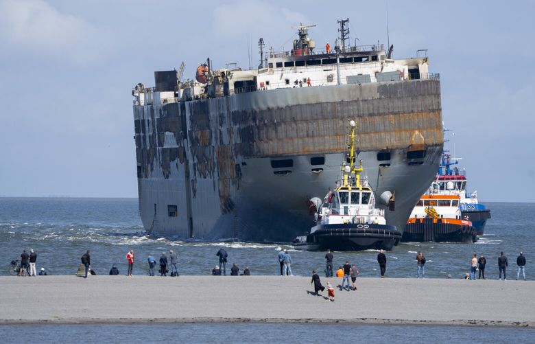 Stricken cargo ship Fremantle Highway, that caught fire while transporting thousands of cars, including nearly 500 electric vehicles, from Germany to Singapore, is towed into the port of Eemshaven, the Netherlands, on Thursday, Aug. 3, 2023. The ship that burned for almost a week close to busy North Sea shipping lanes and a world renowned migratory bird habitat will be salvaged at the northern Dutch port. (AP Photo/Peter Dejong) PDJ107 PDJ107