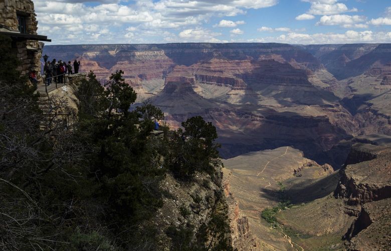 FILE – Tourists look out from the South Rim at the Grand Canyon, May 4, 2023. Arizona Gov. Katie Hobbs is urging President Joe Biden to use the Antiquities Act to designate the tribally proposed Baaj Nwaavjo I’tah Kukveni Grand Canyon National Monument. In a letter dated Tuesday, May 30, Hobbs told Biden that she’s committed to preserving cultural and natural treasures throughout Arizona and said the Grand Canyon is a “culturally sacred place stewarded by Indigenous Peoples for centuries.” (AP Photo/Ty O’Neil, File)
