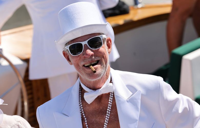 Tom Barghausen is ready for a great weekend on the log boom as his boat, the Match Maker, goes through the Hiram M. Chittenden Locks heading eastbound towards Seafair in Seattle on Friday, August 4, 2023. With a group of friends who have attended Seafair on his boat for over 30 years, they are wearing white celebrating the theme of Dinner en Blanc. Every year they have a different theme and decorate the boat and dress up for it.223651, 224649
