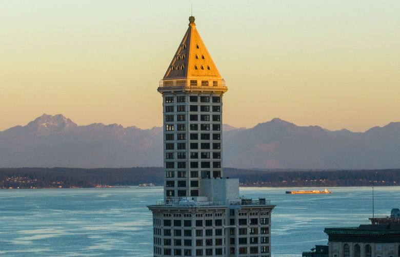 Smith Tower looms over the city of Seattle wakes up by morning light on Aug, 4, 2023.  (Daniel Kim / The Seattle Times)