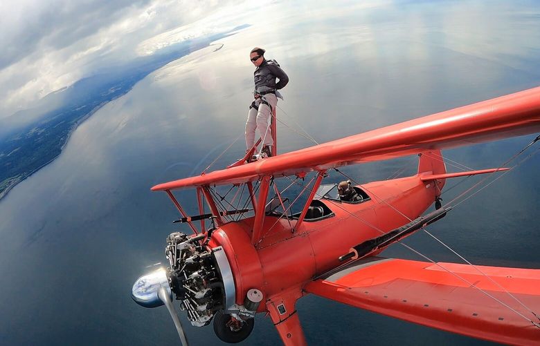Google engineer Jason Mayes strapped to a rig atop a Stearman 450 biplane piloted by Mike Mason during a wing walking flight near Sequim in July 2021. (Courtesy of Mason Wing Walking)