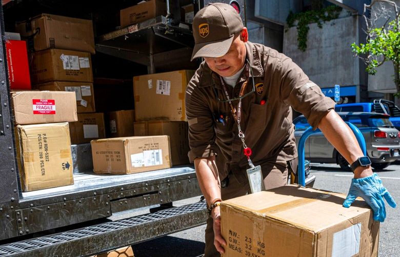 A UPS (United Parcel Service) driver unloads packages for delivery in San Francisco on Tuesday, July 25, 2023. 