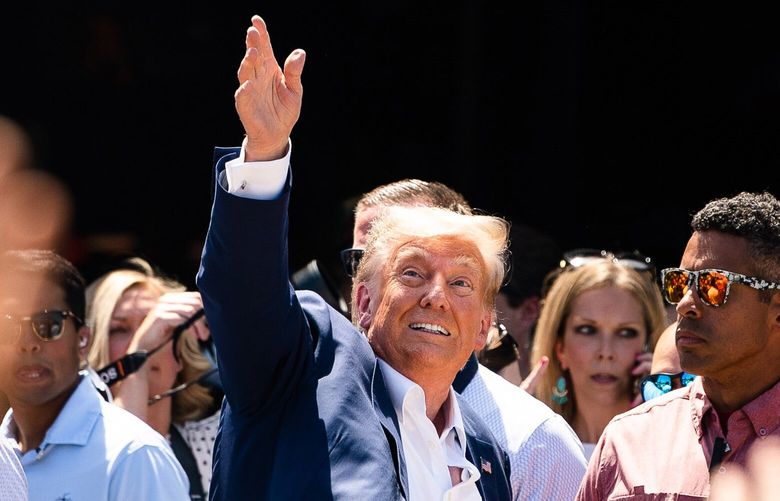 Former president Donald Trump tosses a hat in the air while supporters cheer for him on Aug. 12, 2023, during the 2023 Iowa State Fair, in Des Moines. MUST CREDIT: Washington Post photo by Demetrius Freeman.