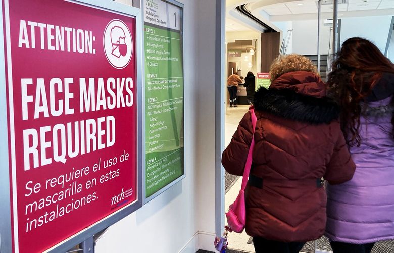 A sign announcing a face mask requirement is displayed at a hospital in Buffalo Grove, Ill., Friday, Jan. 13, 2023. COVID-19 hospital admissions are inching upward in the United States since early July 2023. It’s a small-scale echo of the three previous summers. (AP Photo/Nam Y. Huh) NY873 NY873