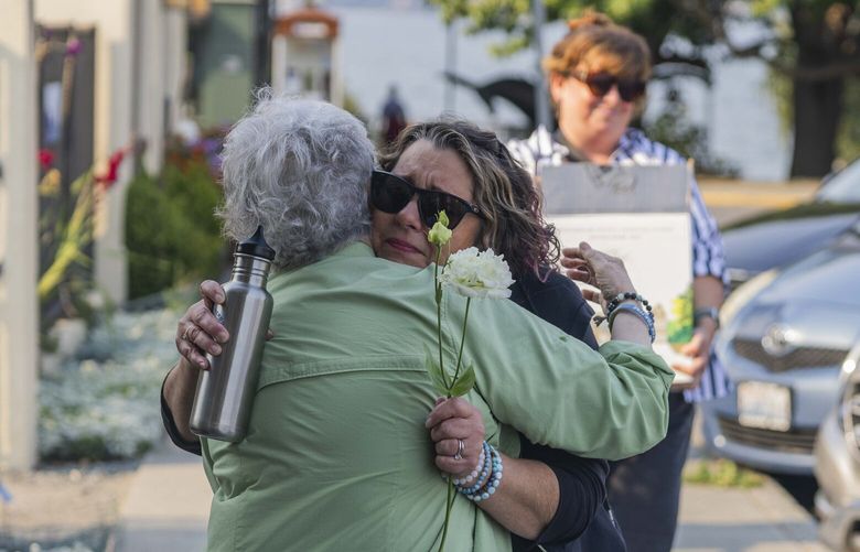 Christina Mullee, center right, embraces Gloria Galey  before a candlelit celebration of Tokitae’s life at the Langley Whale Center on Aug. 19, 2023.