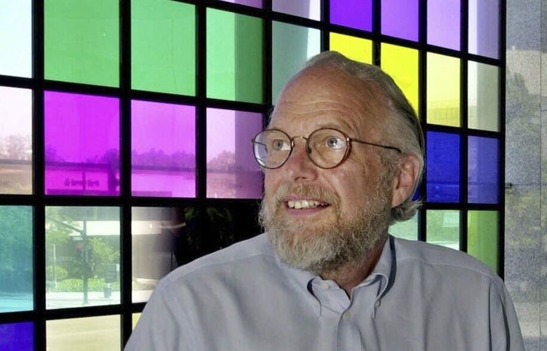 FILE – Co-founder and retired CEO of Adobe Systems Inc. John Warnock stands next to a window of color panes that represent the color swatches in their program PhotoShop at Adobe headquarters in San Jose, Calif., May 9, 2001. Warnock, the inventor of the PDF and Adobe Systems co-founder died Saturday, Aug. 19, 2023, the software company said. (AP Photo/Paul Sakuma, File) NYAB102 NYAB102