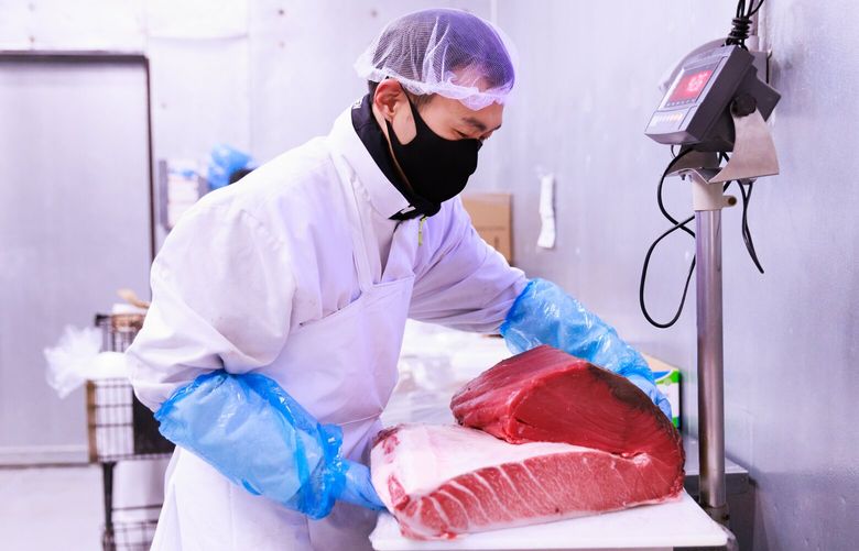 Yul Kim, senior sales manager, weighs a portion of bluefin tuna belly for a customer’s order at Young Ocean’s facility in Kent, Wash. Tuesday, July 18, 2023. The fresh bluefin tuna is often sold at high-end sushi restaurants. 224434