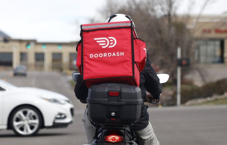 A food delivery rider waits for the traffic light to change to head northbound on Chester Street at County Line Road as a statewide stay-at-home order remains in effect in an effort to reduce the spread of the new coronavirus Monday, March 30, 2020, in Lone Tree, Colo. The new coronavirus causes mild or moderate symptoms for most people, but for some, especially older adults and people with existing health problems, it can cause more severe illness or death. (AP Photo/David Zalubowski)
