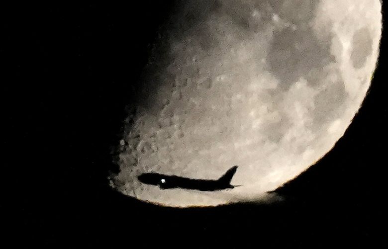 A commercial airliner crosses in front of a Waxing Gibbous moon after taking off from Midway International Airport heading east, Thursday, Aug. 24, 2023, in Chicago. (AP Photo/Charles Rex Arbogast) ILCA101 ILCA101
