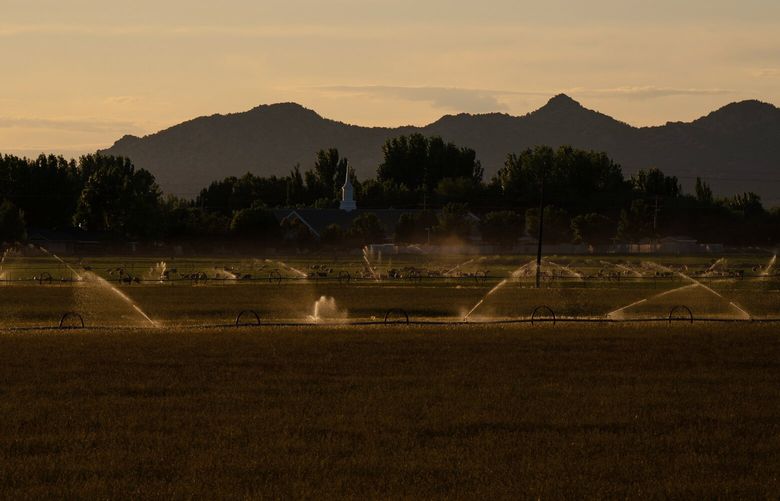 FILE – Irrigation in a field at sunset near Cedar City, Utah, March 24, 2023. A New York Times investigation has found that America is depleting its invaluable reserves of groundwater at a dangerous rate, shrinking aquifers nationwide, threatening supplies of drinking water and America’s status as a food superpower – and climate change is amplifying the problem. (Loren Elliott/The New York Times) XNYT0342 XNYT0342