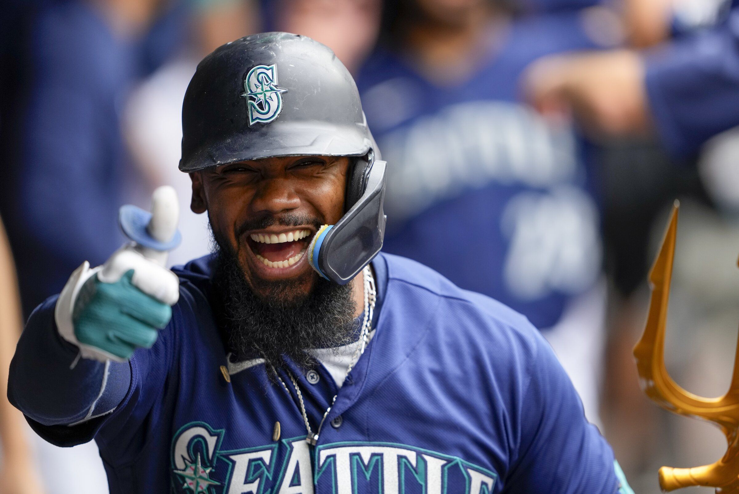 Seattle Mariners' Teoscar Hernandez in the dugout holding the