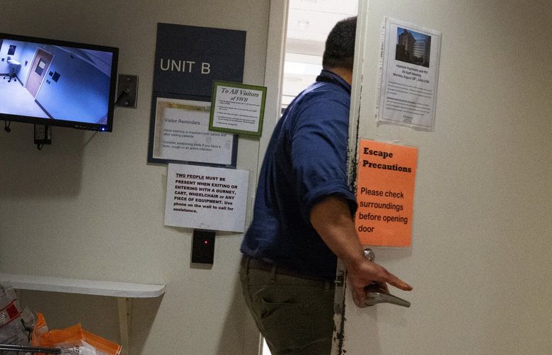 After being buzzed in, a hospital employee enters one of two Psychiatric Acute Care Units at Harborview Medical Center, Tuesday, Aug. 29, 2023, in Seattle. Harborview by far has the best psychiatric inpatient acceptance rates.