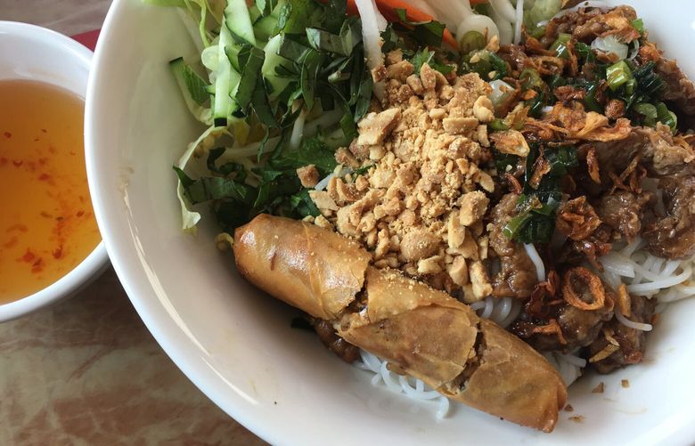 At Seattle Lotus in White Center, everything on the menu is vegetarian, including the “grilled pork” in this vermicelli bowl, served with a crunchy, flavorful egg roll. (Paige Collins / The Seattle Times)
