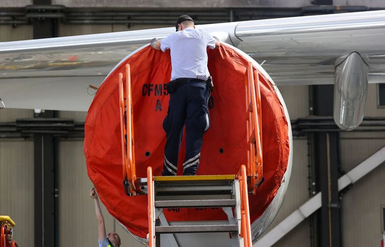 A worker secures a protective cover to a CFM56 turbofan engine on a grounded Airbus SE A340 passenger aircraft, operated by Deutsche Lufthansa AG in Frankfurt, Germany, on July 30, 2020. (Bloomberg)