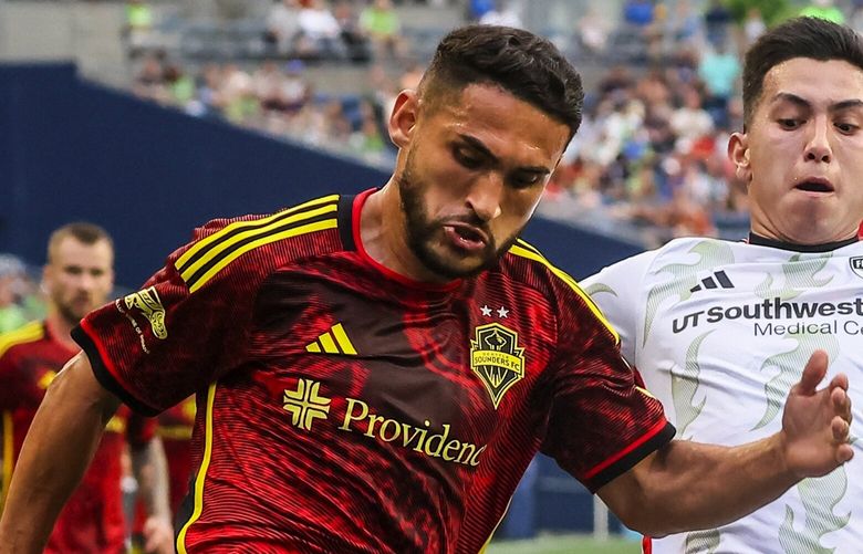 Seattle Sounders midfielder Cristian Roldan controls the ball rushing the baseline with FC Dallas forward Alan Velasco defending Saturday night at Lumen Field in Seattle, Washington on July 15, 2023. The Sounders lead 1-0 at the half.