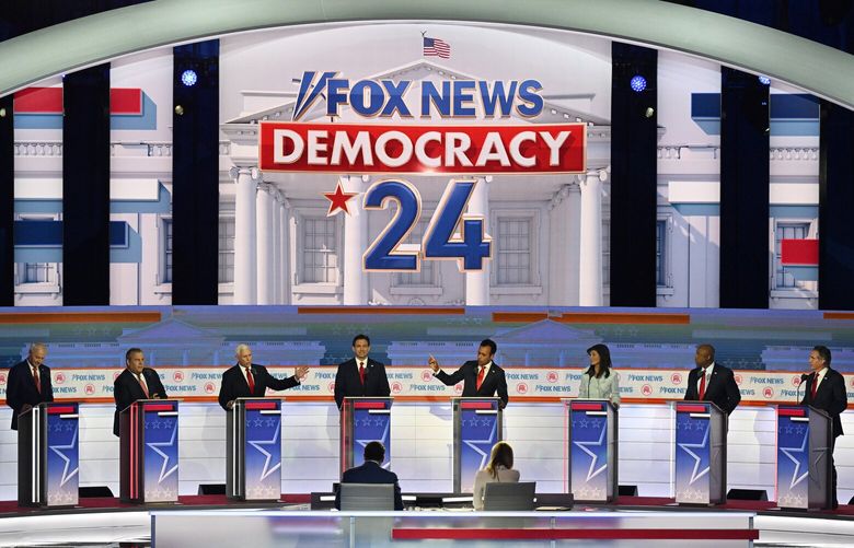 Former vice president Mike Pence (third from left) and businessman Vivek Ramaswamy (fourth from right) speak during the first Republican presidential debate hosted by Fox News in Milwaukee. Few of the candidates were willing to attack former president Donald Trump, who did not attend, by name during the debate. MUST CREDIT: Washington Post photo by Joshua Lott.