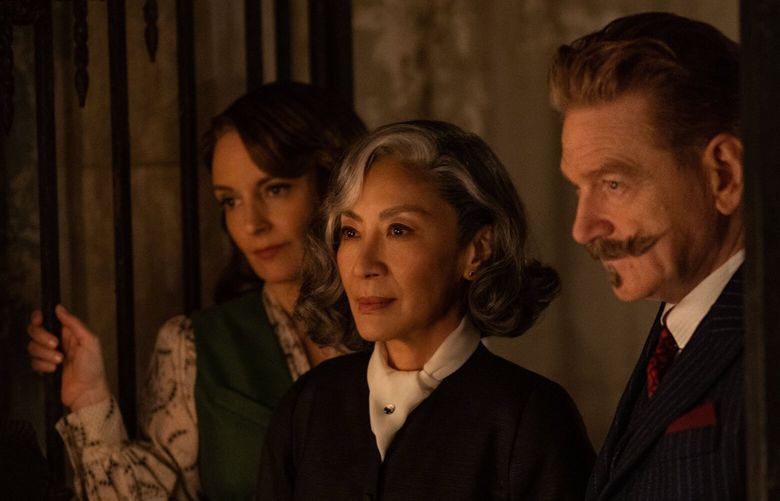 Tina Fey as Ariadne Oliver, from left, Michelle Yeoh as Mrs. Reynolds and Kenneth Branagh as Hercule Poirot in “A Haunting in Venice.”