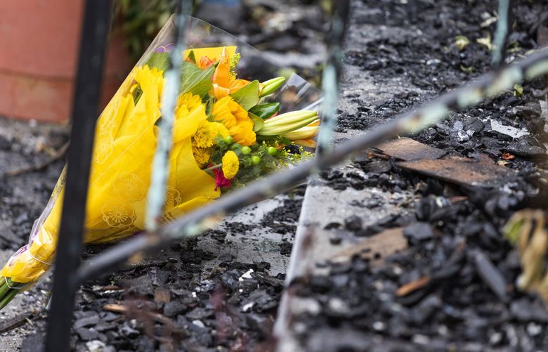 Flowers are left at the scene of a fire, Sunday, Sept. 3, 2023, in Seattle’s Wallingford neighborhood, where 2 adults and 2 children died in a barricaded home Saturday.