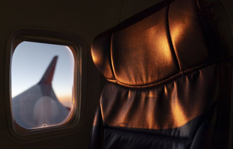 The sun sets outside the window beside an empty seat on a Southwest airplane during a flight from Providence, R.I. to Orlando, Fla., Wednesday, April 21, 2021. (AP Photo/David Goldman) RIDG211