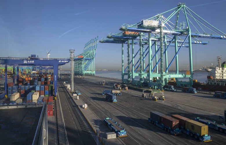 Driverless trucks move shipping containers at an automated port in Tianjin, China, Monday, Jan. 16, 2023. China’s exports fell 7.5% from a year ago in May, 2023, and imports were down 4.5%, adding to signs an economic recovery is slowing. (AP Photo/Mark Schiefelbein)