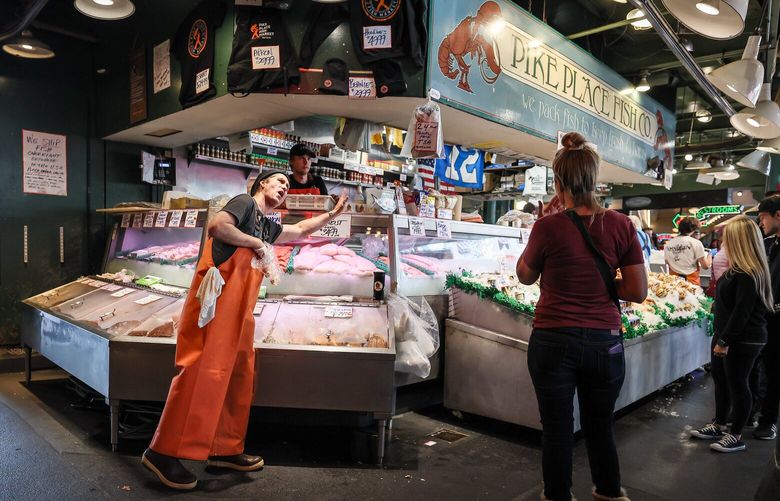 Yori Oyloe hawks the smoke salmon Thursday afternoon at the Pike Place Market in Seattle, Washington on September 7, 2023. The Pike Place Fish Market, Inc has been sued by the market organizers over claims that the business is illegally using the market’s trademarked name for its own product launch in grocery stores. 224925