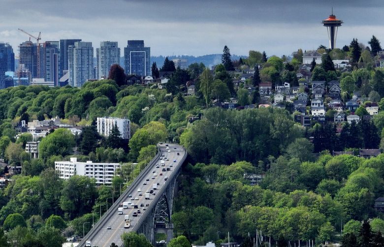 Springtime has brought in lush foliage, as downtown Seattle apartment buildings are seen to the left of Queen Anne Hill and the Space Needle, as traffic moves over the Aurora bridge, Thursday, May 4, 2023 in Seattle.