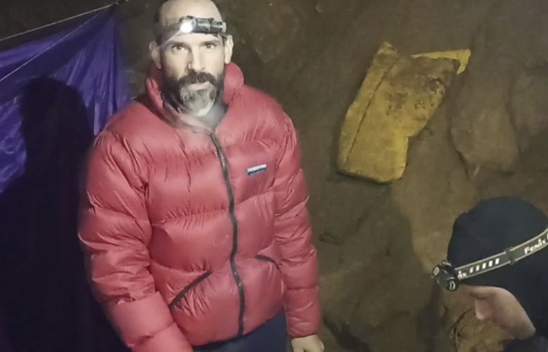 In this screen grab from video, American caver Mark Dickey, 40, talks to camera next to a colleague inside the Morca cave near Anamur, southern Turkey, Thursday, Sept. 7, 2023. Turkish and international cave rescue experts are working to save an American speleologist trapped at a depth of more than 1,000 meters (3,280 feet) in a cave in southern Turkey after he became ill. (Turkish Government Directorate of Communications via AP) FS113 FS113