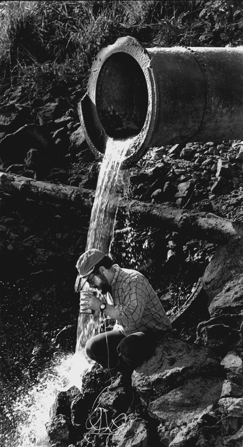 Ken Moser, known as the Puget Soundkeeper, checks a sample for water quality violations at an outflow on the Duwamish in 1991. (Alan Berner / The Seattle Times, 1991)