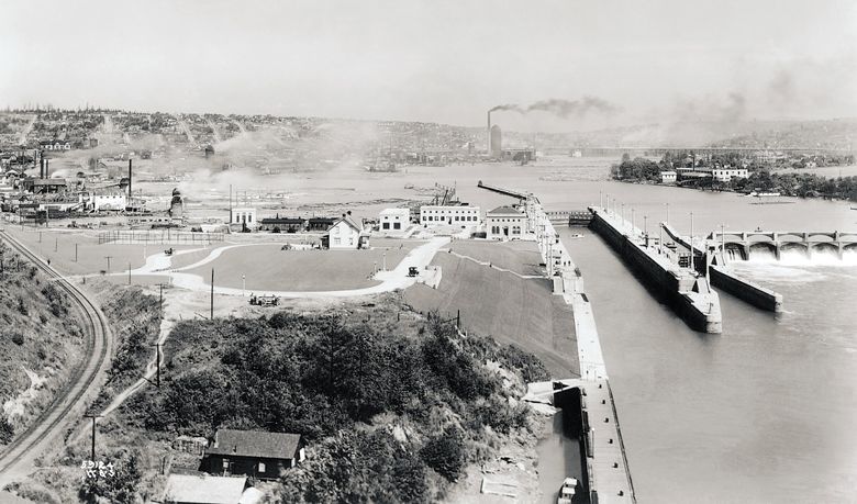 This 1916 view looking east shows the Ballard Locks and administrative buildings at the center, with Salmon Bay and the smokestacks of industrial Ballard beyond. (The Seattle Times File, 1916)