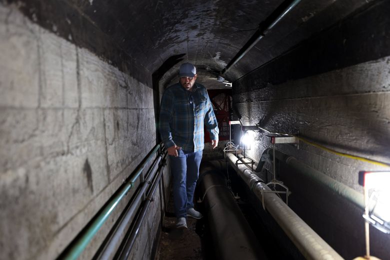David Chapman, project engineer with the U.S. Army Corps of Engineers, walks in the utility tunnel that crosses from below the pumphouse in the Ballard Locks administration building to the other side of the large lock chamber. Regarding the administration building, Chapman says, &#8220;[People] don&#8217;t know there’s this deeply industrial heart to it.” (Karen Ducey / The Seattle Times)