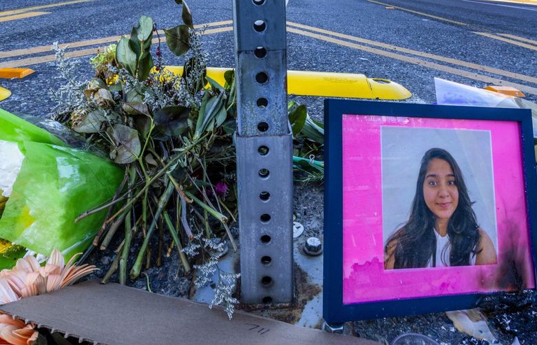 A photo of Jaahnavi Kandula is seen with flowers, Sunday, Jan. 29, 2023 in Seattle, at the intersection where she was killed by a Seattle Police officer driving north while responding to a nearby medical incident. This view of Dexter looks north. Nearby, a rally saw about 50 gather to protest police violence. 222920
