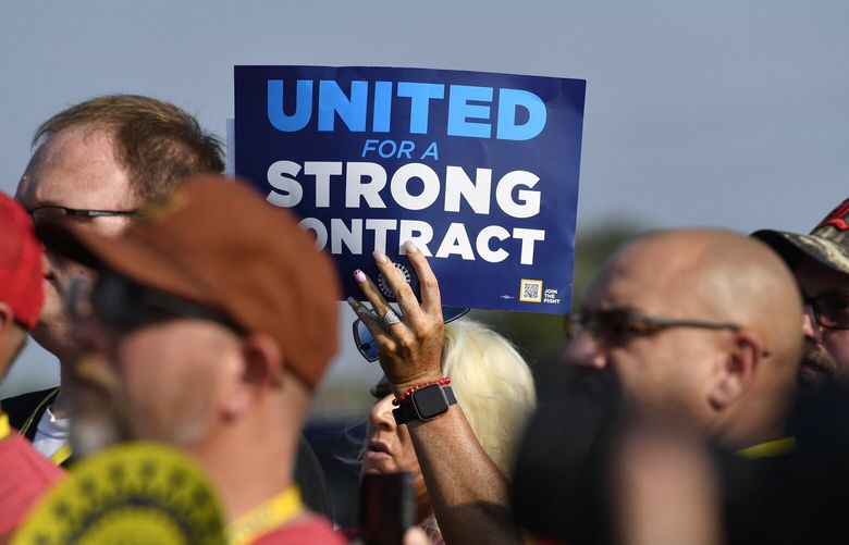 File – A member holds up a sign at a rally by United Auto Workers Local 863 in Louisville, Ky., on Aug. 24, 2023. eaders of the UAW union are considering targeted strikes at a small number of factories run by each of Detroit’s three automakers if they can’t reach contract agreements by a Thursday night, Sept. 12 deadline. (AP Photo/Timothy D. Easley, File) CAPU202 CAPU202