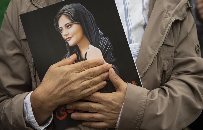 FILE – A portrait of Mahsa Amini is held during a rally calling for regime change in Iran following the death of Amini, a young woman who died after being arrested in Tehran by Iran’s notorious “morality police,” in Washington, on Oct. 1, 2022. Iran’s foreign ministry on Sunday May 21, 2023 summoned the Swiss ambassador, Nadine Lozano, after a Twitter account affiliated with the embassy in Tehran published a photo showing protest icon Mahsa Amini, reported YJC.ir, a website affiliated with Iran’s state TV. (AP Photo/Cliff Owen, File) BGK101