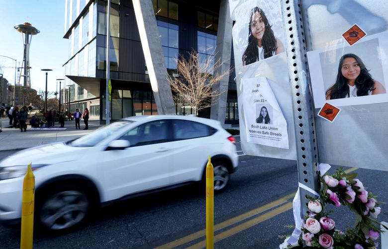 With the Space Needle in view at left, photos of Jaahnavi Kandula are seen Jan. 29, 2023 at the Seattle intersection where she was killed by a Seattle police vehicle responding to an emergency call. Some Seattle elected officials are calling for increased police accountability after release of footage of an officer joking after the death of Kandula.