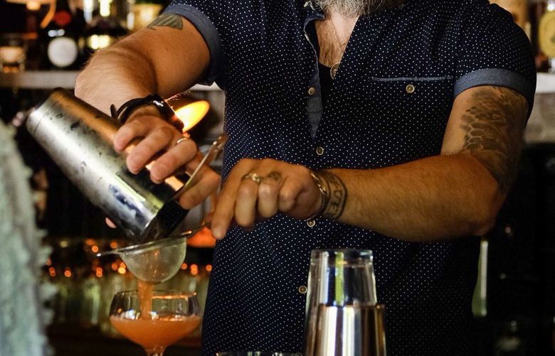 Bar Americano in Edmonds is the new amaro den from the same owner behind the stellar craft cocktail haunt Daphnes. Picture here is Bartender Gabriel Koller behind the bar mixing a drink.
